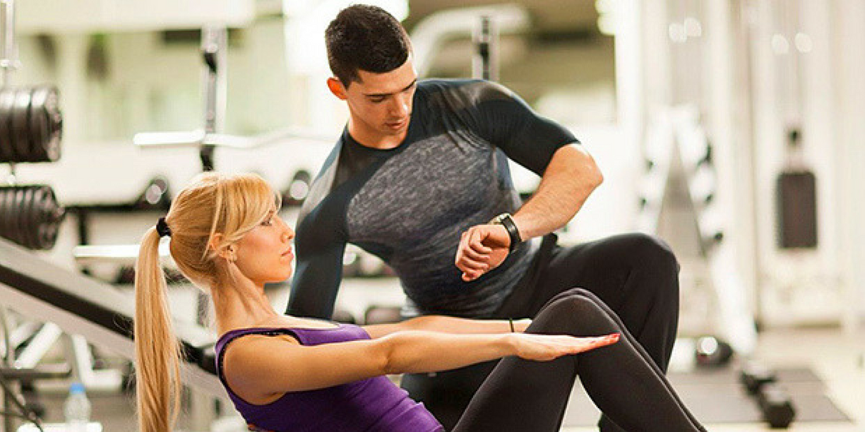 Fitness professional guiding a client.
