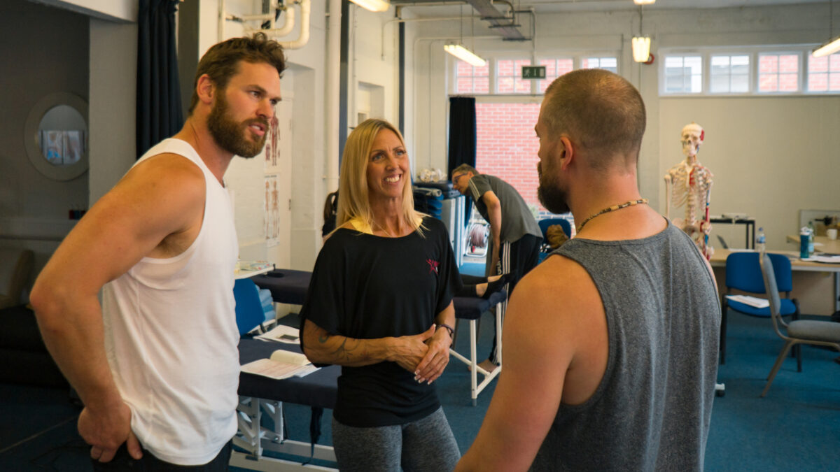 Rachel and wo men discuss a biomechanics workshop - in a learning setting.