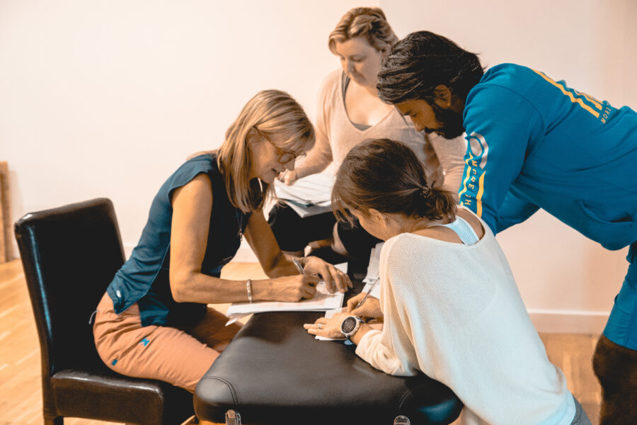 four people, one man, three woman, working together and taking notes.